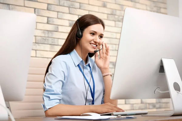 Female technical support operator with headset at workplace