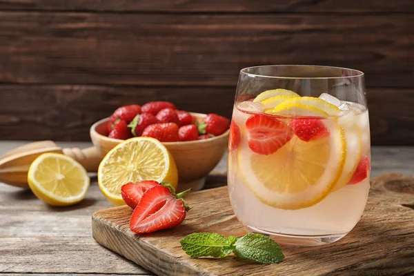 Natural lemonade with strawberries in glass on table