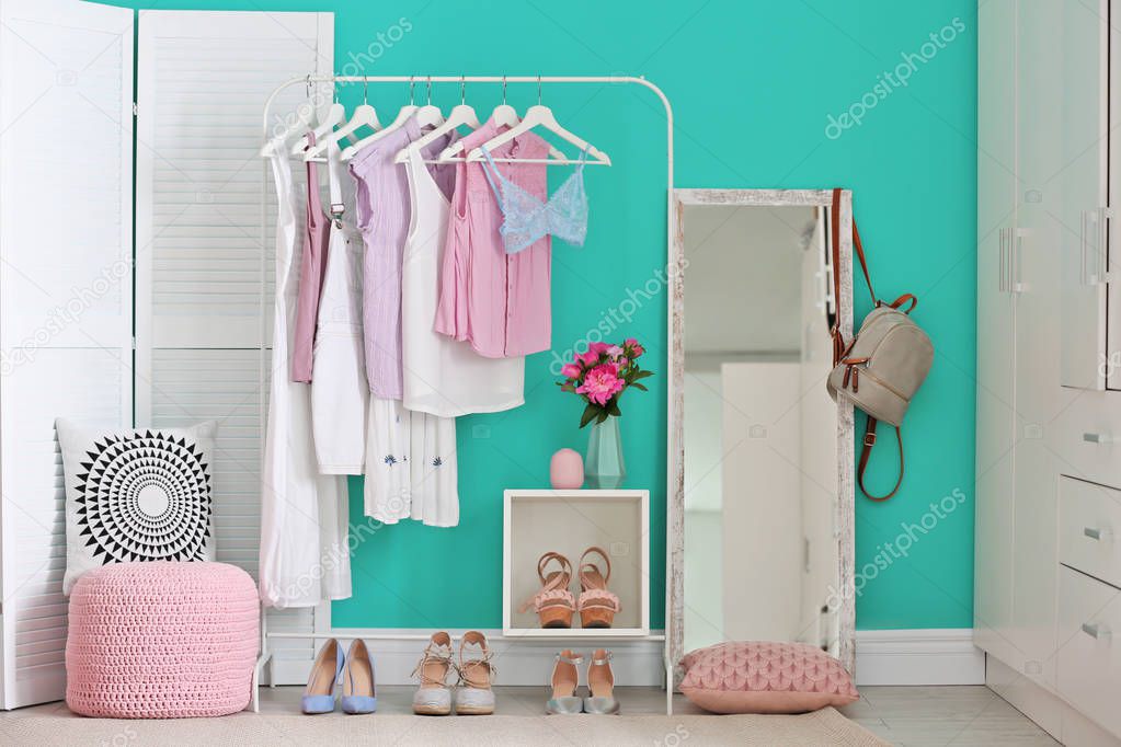 Stylish dressing room interior with clothes rack and mirror