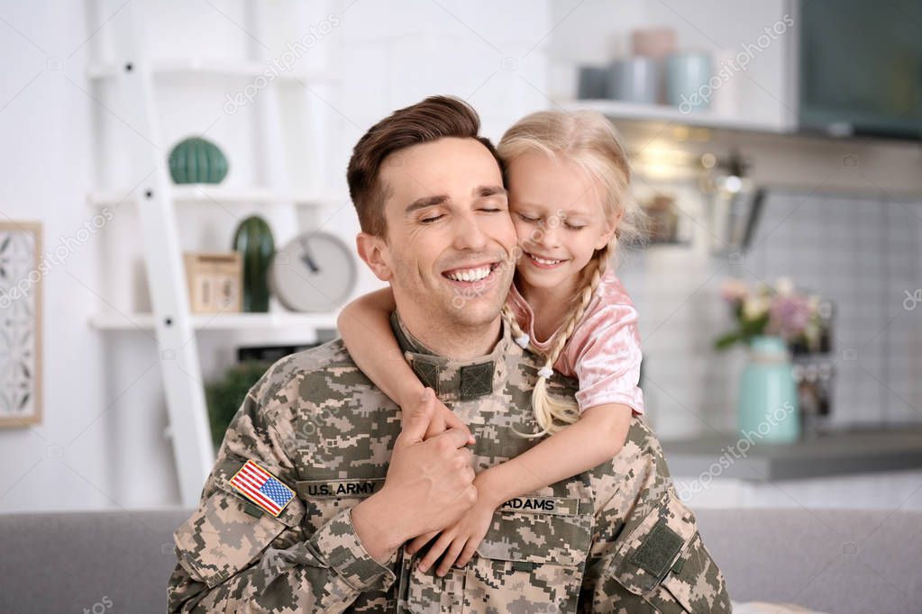Young man in military uniform with his little daughter at home