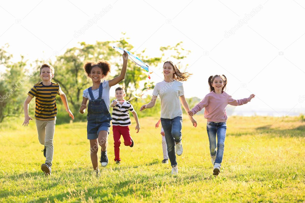 Cute little children playing with kite outdoors on sunny day