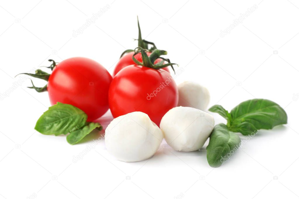 Ripe red tomatoes, mozzarella cheese balls and basil on white background