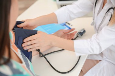 Kadın doktor Kliniği içinde kilolu kadın kan basıncı ölçme