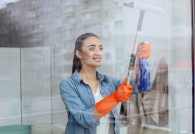 Genç kadın pencere cam evde temizlik