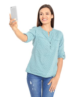Selfie beyaz bir arka plana dayanır alarak genç güzel kadın