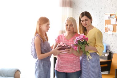 Genç kadın kızı tebrik olgun aile üye vasıl ev ile. Mutlu anneler günü