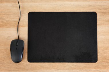 Blank pad and computer mouse on wooden background, top view clipart