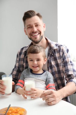 Baba ve oğul kahvaltı süt ile masada olması