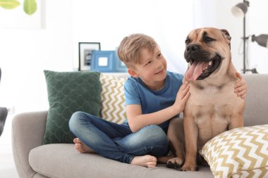 Sevimli küçük çocuk ile köpek evde kanepede