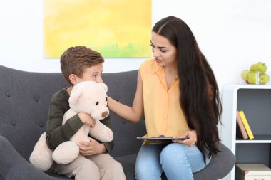 Çocuk psikoloğu ofiste bir çocukla çalışıyor.