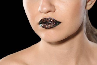 Güzel genç model siyah arka plan üzerine yaratıcı dudak makyaj ile