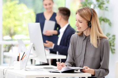 Ofiste masasında kulaklık ile kadın resepsiyonist