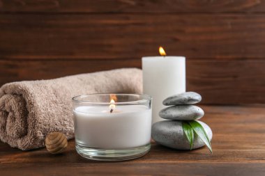 Spa taşlar, havlu ve ahşap masa üzerinde yanan mumlar güzel kompozisyon