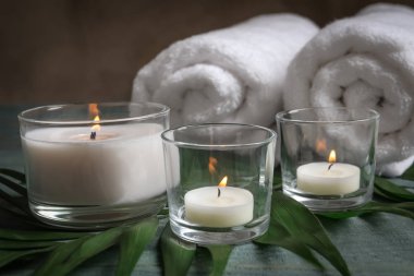 Mum, havlu ve tropikal yaprak masaya yanma ile spa kompozisyon