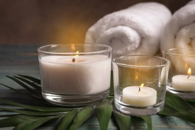 Mum, havlu ve tropikal yaprak masaya yanma ile spa kompozisyon