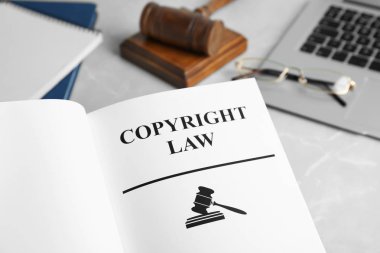 Kitap Telif Hukuk kelimelerle, dizüstü bilgisayar ve tablo, closeup tokmak