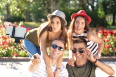 Bir grup genç insan selfie monopod açık havada, odak üstünde smartphone ile alarak