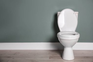Yeni seramik klozet gri duvarının yakınında