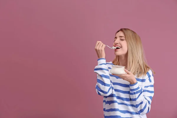 Молодая Привлекательная Женщина Ест Вкусный Йогурт Цветном Фоне — стоковое фото