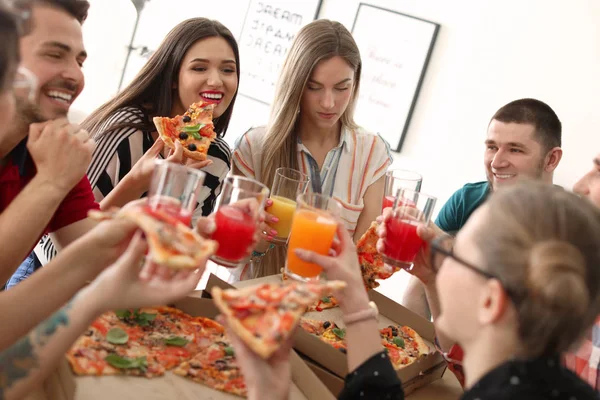 年轻人有愉快的党与美味的比萨室内 — 图库照片
