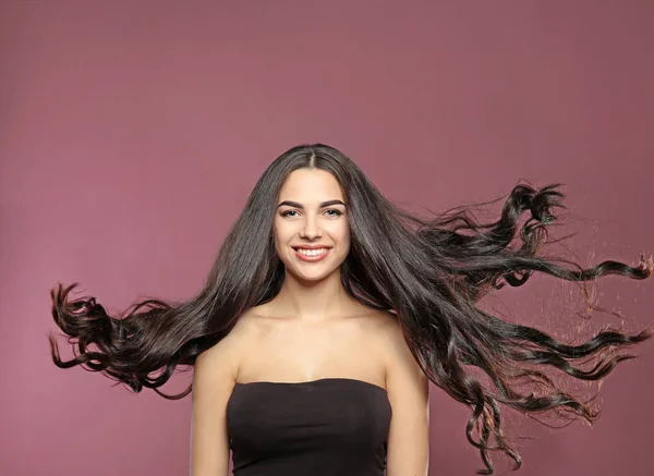 色背景にゴージャスな巻き毛の美しいモデルの肖像 — ストック写真