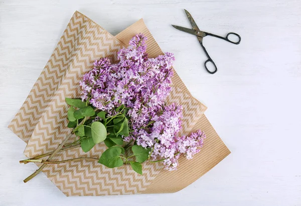 Flat lay composition with beautiful blossoming lilac on light background. Spring flowers