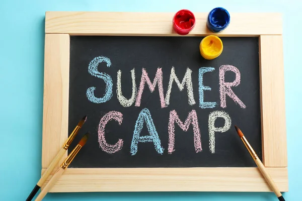 Texto Summer Camp Sobre Chalkboard Pincéis Tintas Vista Superior — Fotografia de Stock