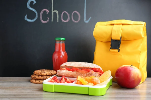 ランチ ボックスと Word 学校で黒板の近くのテーブルの上にバッグの食欲をそそる食べ物 — ストック写真