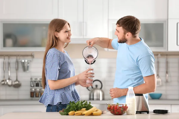 Jovem Derramando Delicioso Batido Leite Vidro Para Sua Namorada Cozinha — Fotografia de Stock