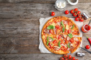 Domates ve ahşap arka plan üzerinde et lezzetli pizza