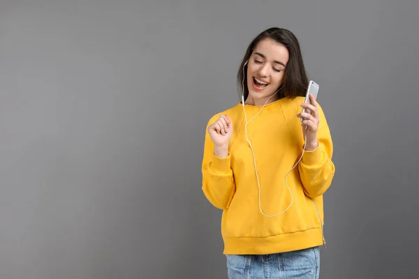 Νεαρή Γυναίκα Χρησιμοποιώντας Τηλέφωνο Για Ακούτε Μουσική Κατά Χρώμα Φόντου — Φωτογραφία Αρχείου