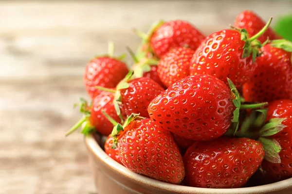 Cuenco con fresas frescas maduras en la mesa, primer plano — Foto de Stock