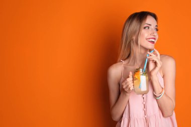 Mason kavanoza lezzetli limonata renk arka plan üzerinde olan kadın. Doğal detoks içecek