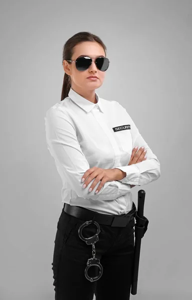 Female security guard in uniform on color background