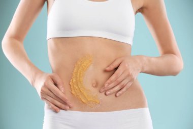 Genç kadının karnı renk arka plan, closeup karşı doğal fırçalayın uygulayarak