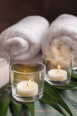 Mum, havlu ve tropikal yaprak masaya yanma ile spa kompozisyon