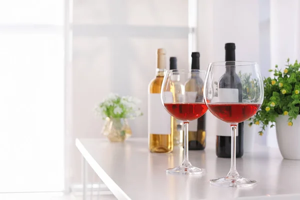 ガラスと室内のテーブルに美味しいワインのボトル — ストック写真