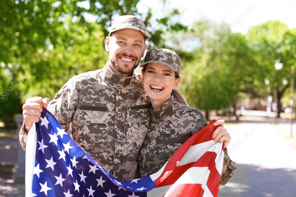 Military couple with American flag in park
