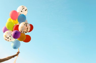 Güneşli günü açık havada renkli balonlar ile genç kadın
