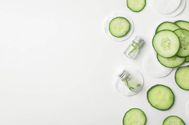 Düz taze salatalık Cilt Bakımı ile kompozisyon tonik ve pamuk pedler beyaz arka plan üzerinde yatıyordu