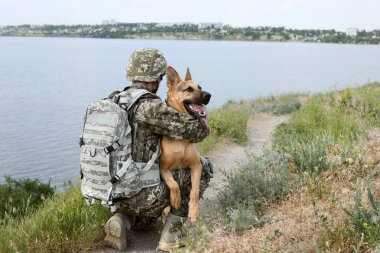 Alman çoban köpek açık havada ile askeri üniformalı erkeklere