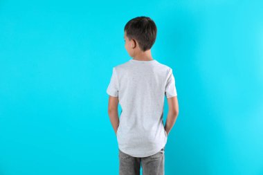 Renk arka plan üzerinde küçük çocuk t-shirt içinde. Tasarım mock-up
