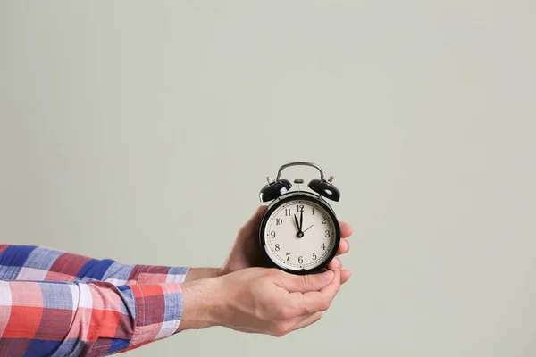 Joven Con Despertador Sobre Fondo Gris Concepto Tiempo —  Fotos de Stock