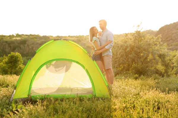 Young couple near camping tent in wilderness