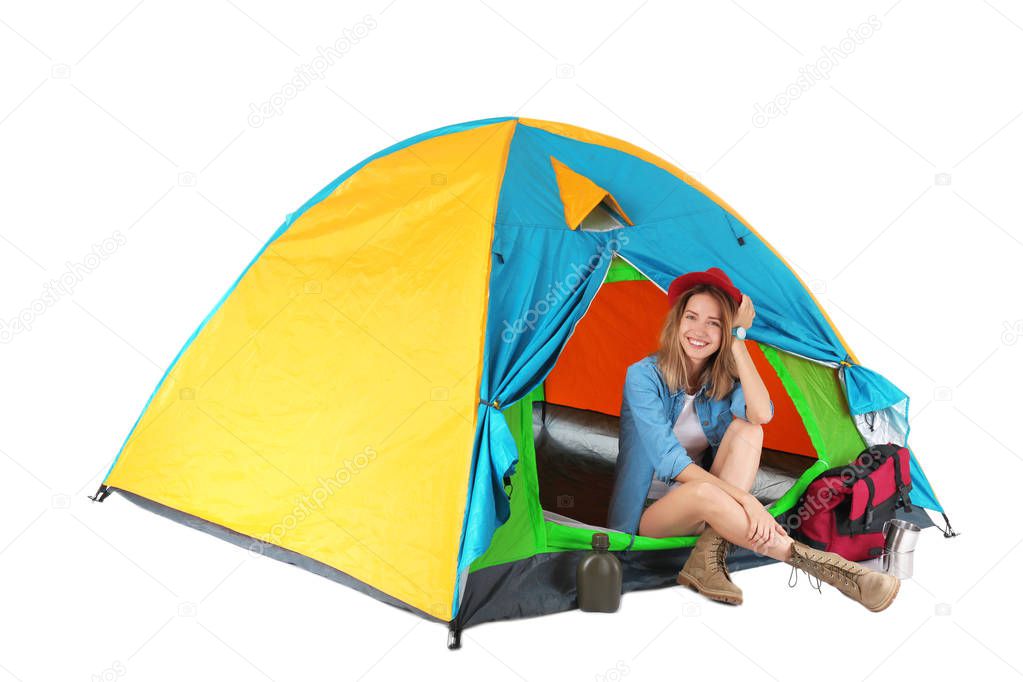 Young beautiful woman sitting in tourist tent on white background