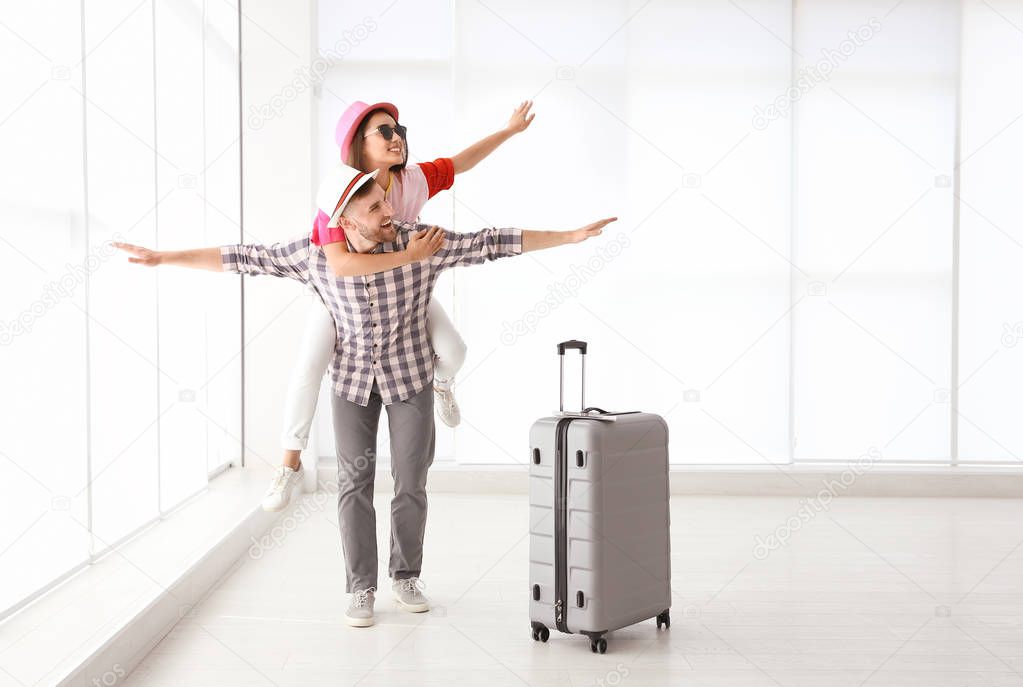 Young couple with suitcase in airport