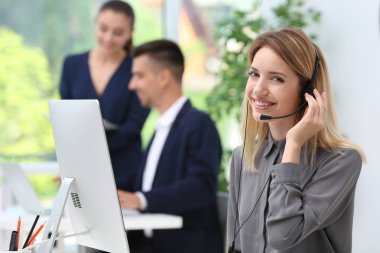 Ofiste masasında kulaklık ile kadın resepsiyonist