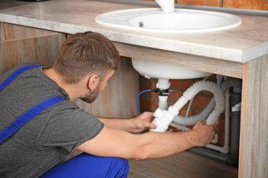 Lavabo kapalı sabitleme üniformalı profesyonel tesisatçı