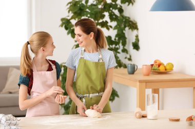 Anne ve kızı mutfakta masada hamur yapma