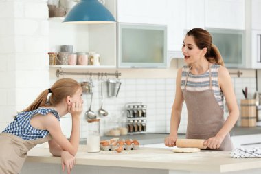 Anne ve kızı mutfakta masada hamur yapma